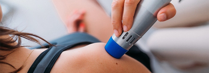 Chiropractic Bellevue WA Cold Laser Therapy A patient with a cold laser therapy wand on their c\shoulder.