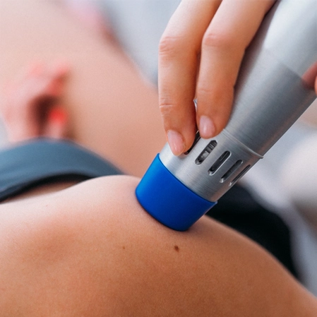 Cold laser on a patients shoulder.