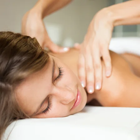 A massage therapist working on a patients shoulders.