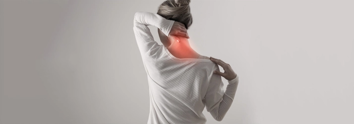 Chiropractic Bellevue WA Neck Pain A black and white photo of a person holding their neck, with the neck area highlighted in red