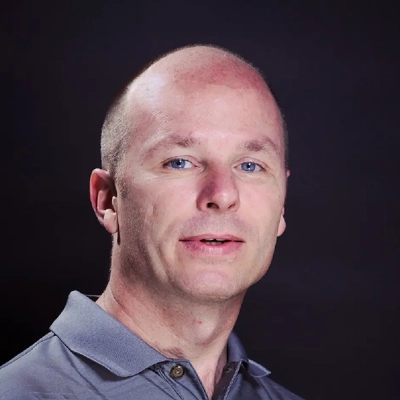 Shane King smiling in a grey shirt.