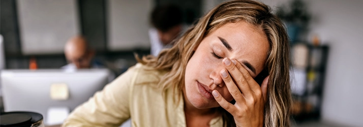 Chiropractic Bellevue WA Woman Stressed A blonde woman showing signs of stress, with her hand pressed to her forehead.