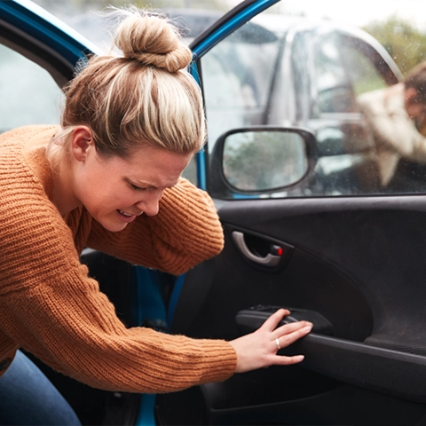 A woman holding her neck after a car accident.
