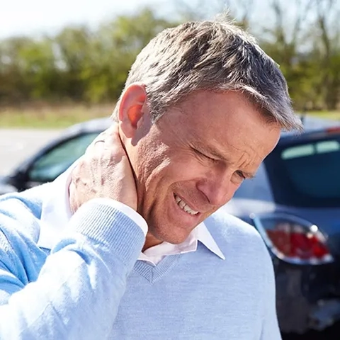 A man holding his neck after a car accident.